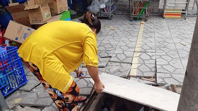 Nắp cống trước nhà (đường số 2, phường Bình Hưng Hòa B, quận Bình Tân) bị mất, chị Hoa tự đặt tấm ván và vài thanh sắt chắn tạm lên miệng cống để không nguy hiểm cho người đi đường.