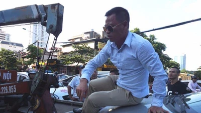 Tài xế 'cố thủ' trên nắp capo khi xe bị cẩu đi