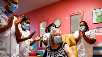 Các nhân viên bệnh viện Rene-Muret, ngoại ô thủ đô Paris vỗ tay chúc mừng người Pháp đầu tiên được tiêm vaccine ngừa COVID-19 hôm 27-12-2020. Ảnh: REUTERS