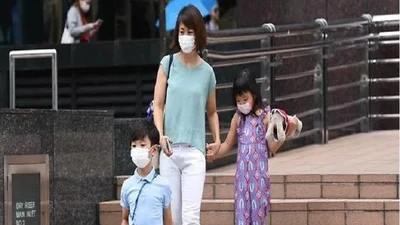 Người dân mang khẩu trang khi đi ra ngoài tại Singapore. Ảnh: CHANNEL NEWS ASIA