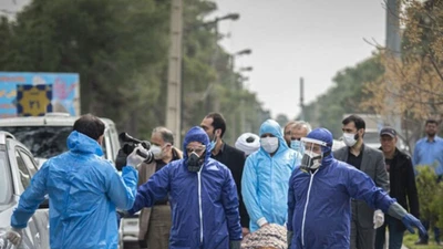 Nhân viên y tế di chuyển môt bệnh nhân tử vong do COVID-19 ở tỉnh Mazandaran (Iran) ngày 7-3. Ảnh: AFP