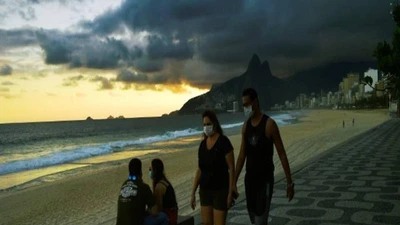 Người dân đeo khẩu trang đi dạo trên bãi biển ở Rio de Janeiro. Ảnh: AFP
