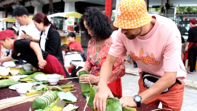 Du khách nước ngoài hào hứng trải nghiệm gói bánh tét