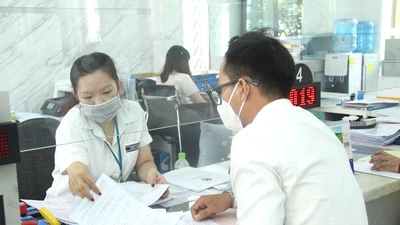 Cán bộ quận 1 giải quyết nhanh thủ tục hành chính cho người dân. Ảnh: LÊ THOA