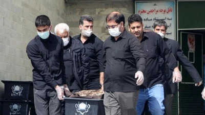 Một cỗ quan tài của bệnh nhân COVID-19 được khiêng đi tại nghĩa trang Beheshte Masoumeh ở TP Qom (Iran).