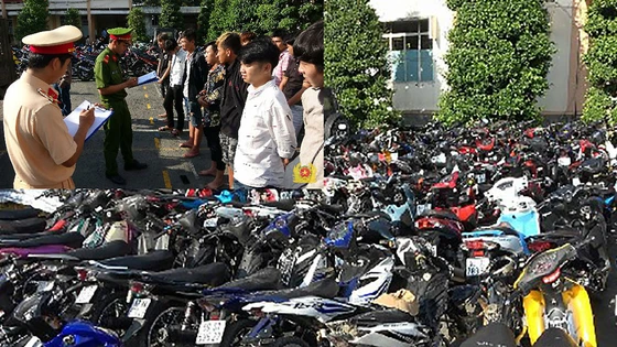 Công an làm việc với nhóm đua xe (ảnh nhỏ) và tang vật đua xe trái phép trên quốc lộ 1 vào rạng sáng 11-4 bị bắt giữ.