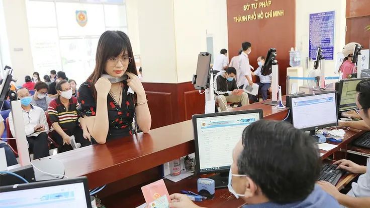 Người dân mang theo sổ hộ khẩu khi làm thủ tục hành chính ở Sở Tư pháp TP.HCM. Ảnh: HOÀNG GIANG
