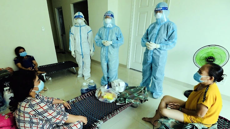 Sư cô Nhuận Bình (người mặc đồ bảo hộ ở giữa) đến các phòng bệnh nhẹ để động viên bệnh nhân.