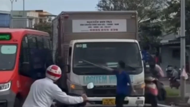 Tài xế xe tải chặn xe, cầm thanh sắt thách thức tài xế xe buýt. Ảnh: TN