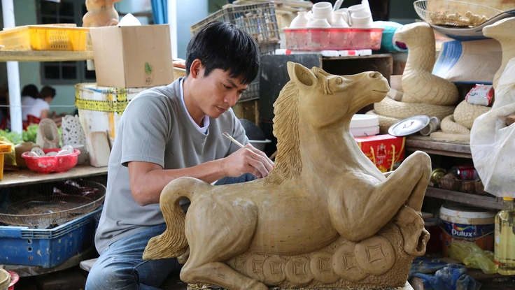 Nghệ nhân làm linh vật ngựa bằng gốm.