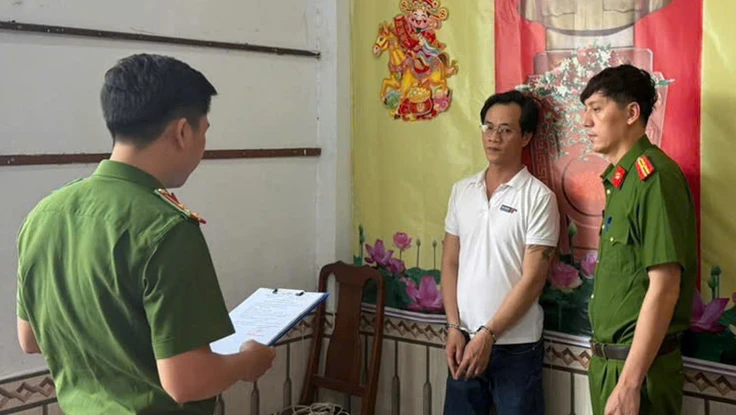 Công an đọc lệnh bắt bị can Huy. Ảnh: CA