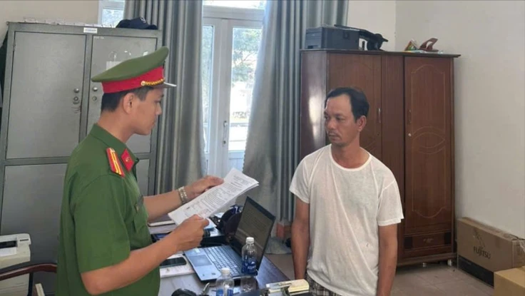 Công an đọc lệnh bắt Danh. Ảnh: CA