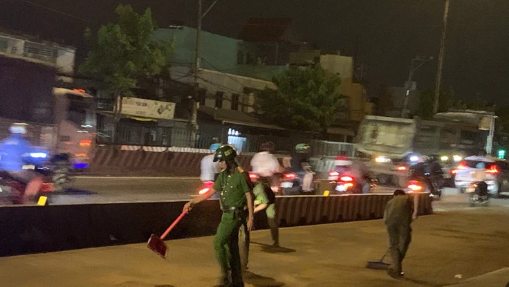 Công an phường Đông Hưng Thuận dọn cát trên đường đảm bảo an toàn cho người dân