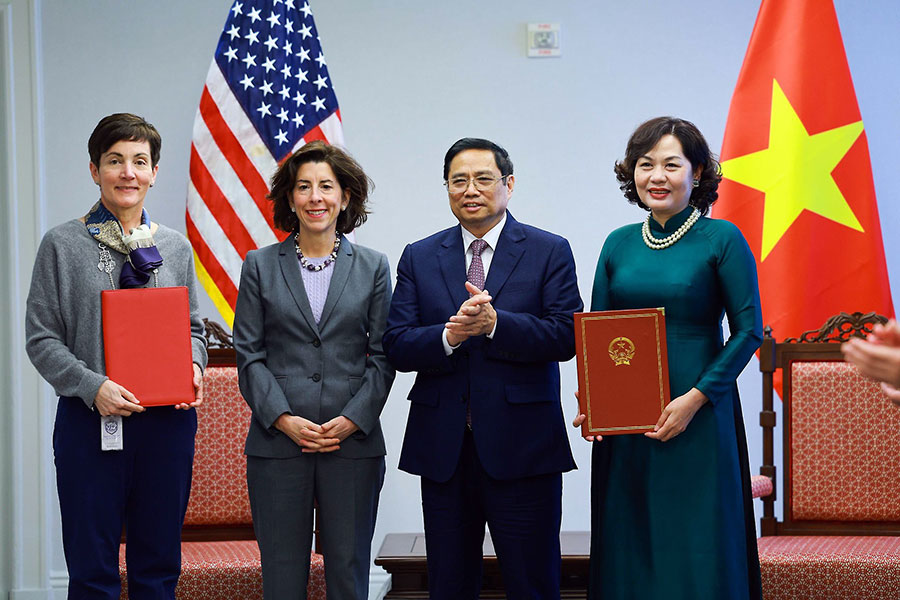 Thủ tướng Phạm Minh Chính và Bộ trưởng Thương mại Mỹ Gina Raimondo (thứ hai từ trái) chứng kiến việc trao thỏa thuận hợp tác về hỗ trợ xây dựng khuôn khổ pháp lý về tiêu chuẩn môi trường và xã hội trong đầu tư, cấp tín dụng của các tổ chức tín dụng Việt Nam (sự kiện diễn ra tại Mỹ, tháng 5-2022).
