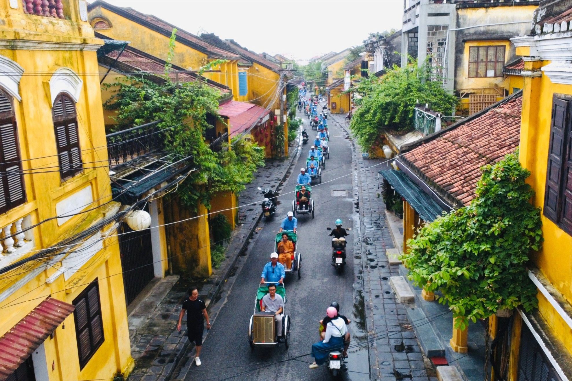 Du khách đi xe đạp, xích lô diễu hành Hội An được UNESCO vinh danh là thành phố sáng tạo toàn cầu. Ảnh: TN