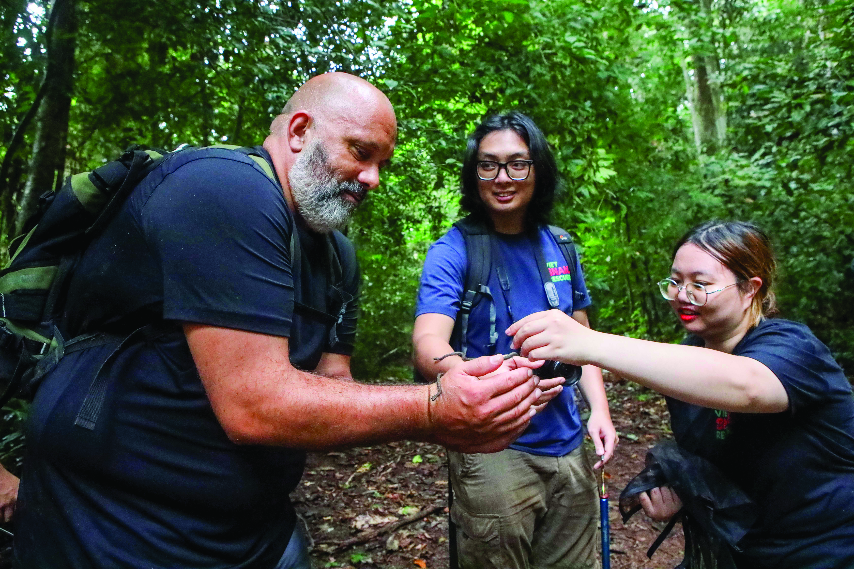 Anh Nguyễn Hoàng Lĩnh (giữa), trưởng nhóm Viet Snake Rescue, cùng những người bạn tái thả rắn. Ảnh: TẤN LỘC - NG.NHI