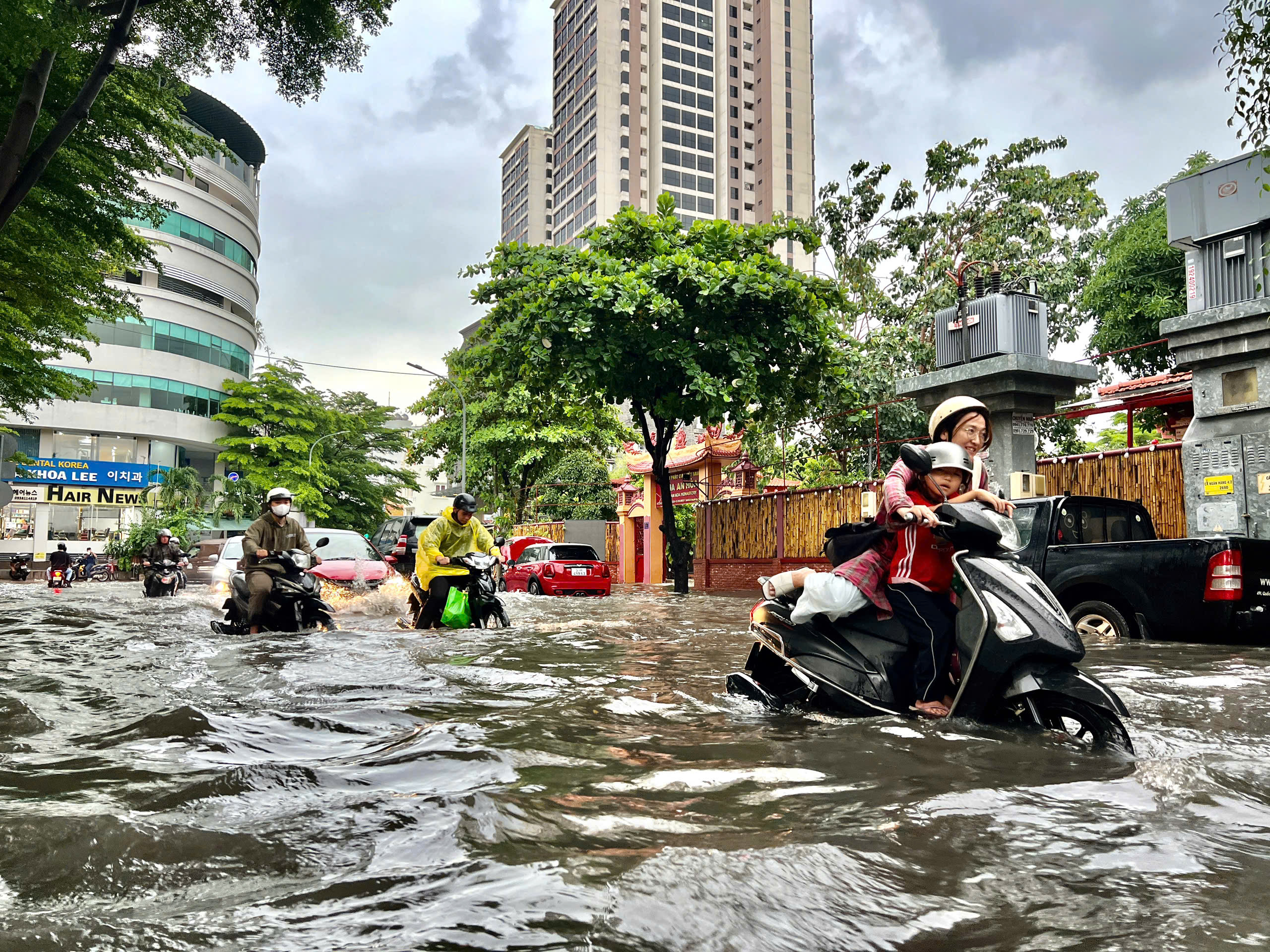 TP.HCM mưa lớn kéo dài, nhiều người vất vả vượt nước ngập về nhà
