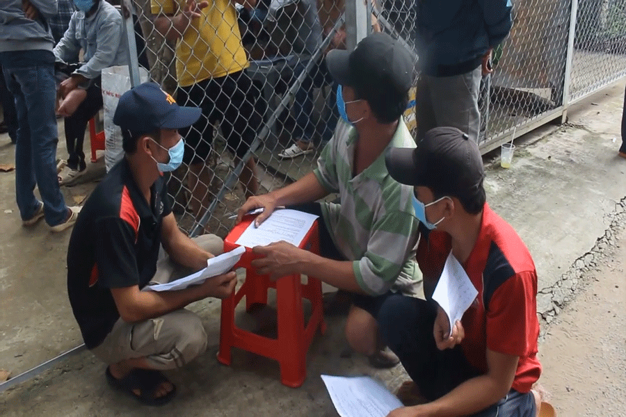 Người dân làm thủ tục trước khi được test nhanh COVID-19. Ảnh: ĐH