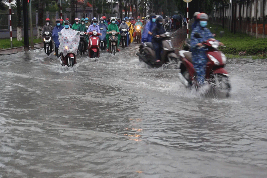 Công nhân tan ca lội bì bõm trong biển nước. Ảnh: ĐH