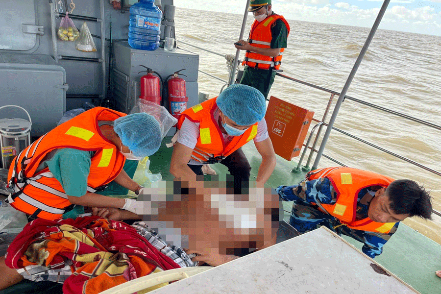 Lực lượng Bộ đội Biên phòng sơ cứu cho nạn nhân và đưa vào bờ. (Ảnh: Đồn Biên phòng Hàm Luông cung cấp)