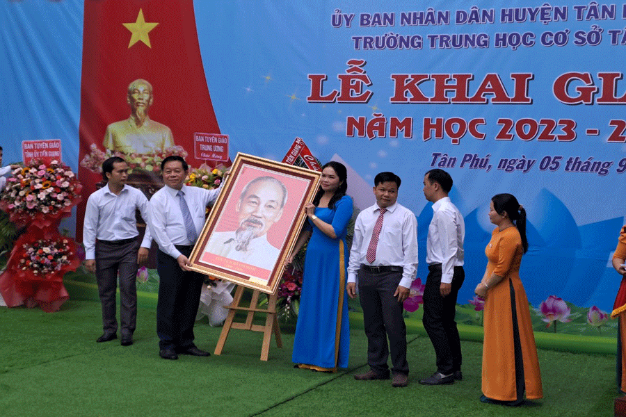 Trưởng Ban Tuyên giáo Trung ương tặng bức tranh chân dung Bác Hồ cho trường THCS Tân Phú. Ảnh: ĐÔNG HÀ Trưởng Ban Tuyên giáo Trung ương tặng bức tranh chân dung Bác Hồ cho trường THCS Tân Phú. Ảnh: ĐÔNG HÀ