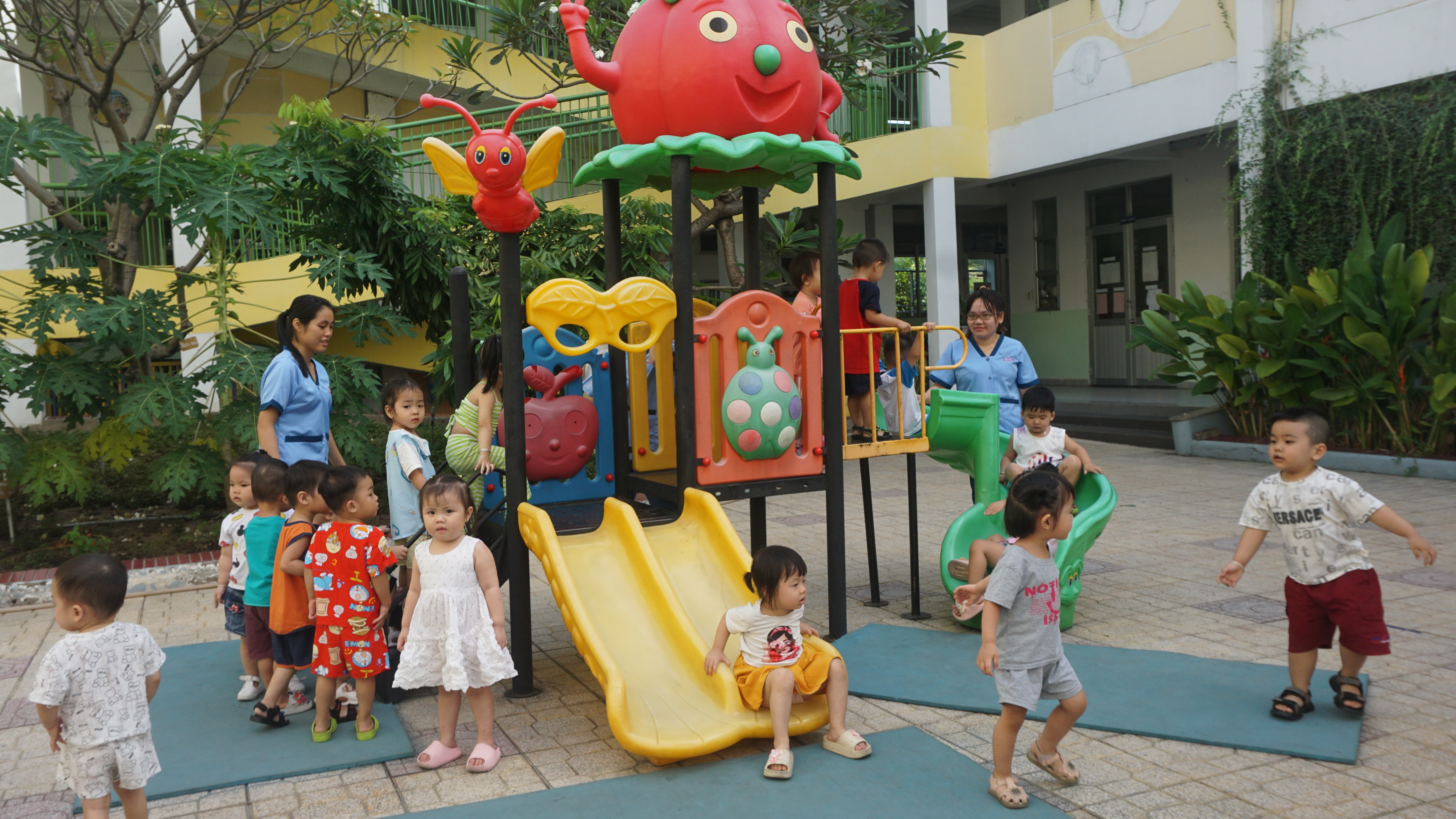 Cô và bé Trường Mầm non Mặt Trời Nhỏ đang vui chơi ngoài trời trong giờ giải lao. Ảnh: NGUYỄN QUYÊN