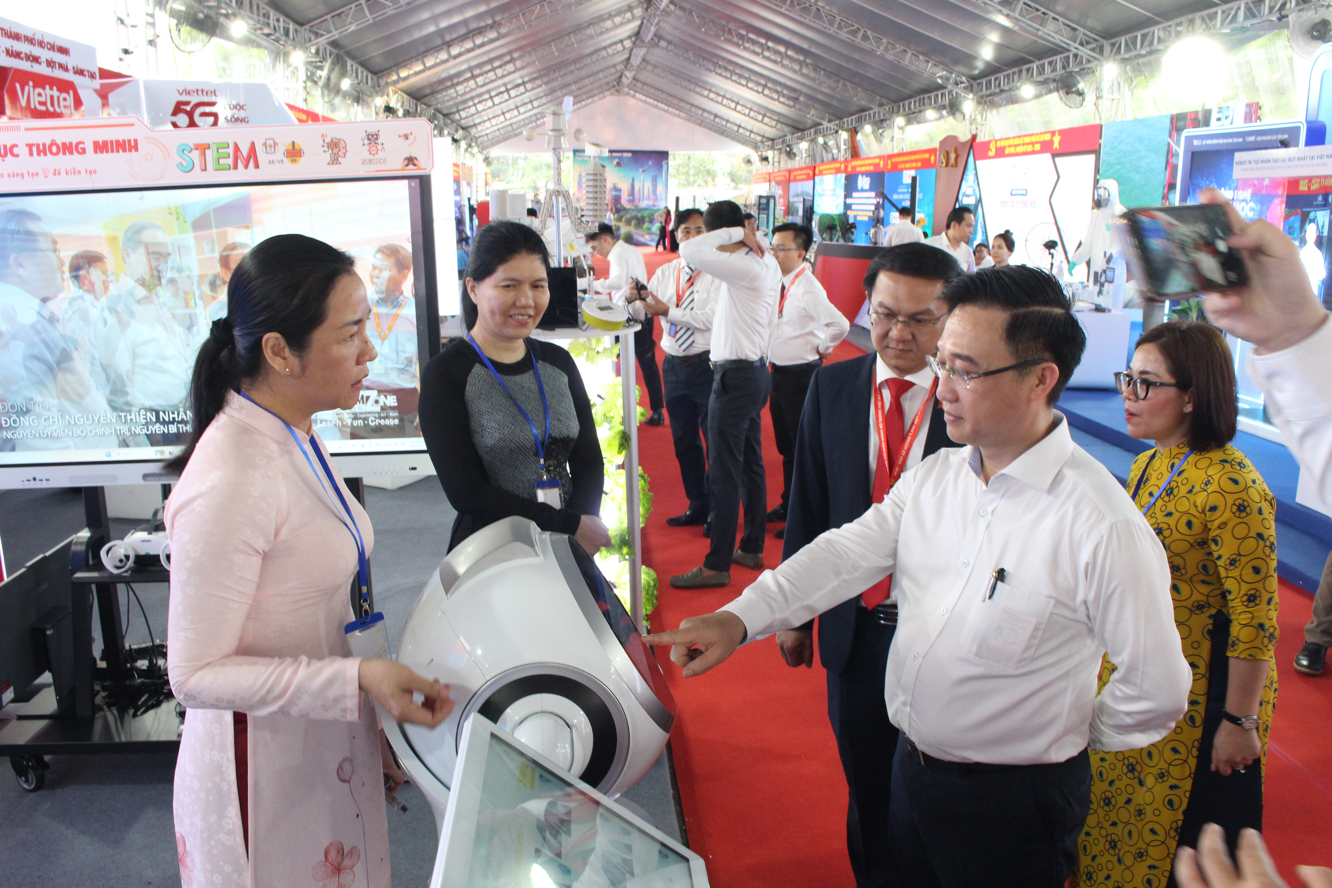 Phó Bí thư Thành ủy TP.HCM Đặng Minh Thông (áo trắng), Giám đốc Sở KH&CN Lâm Đình Thắng cùng các đại biểu tham quan các gian hàng triển lãm trưng bày về công nghệ trong khuôn khổ Đại hội Đảng bộ TP.HCM lần thứ I vào giữa tháng 10-2025. Ảnh: BTC