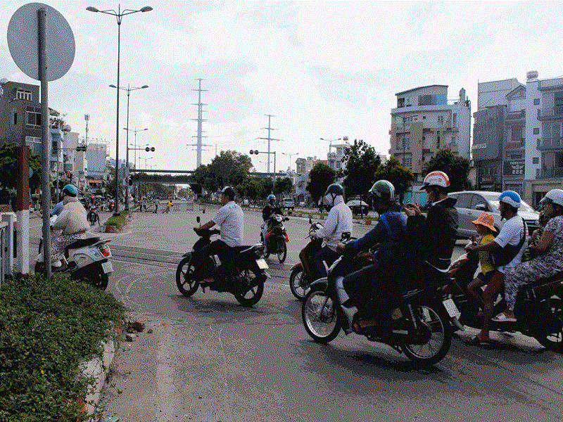Liều mạng qua đường giữa ray tàu trên đường Phạm Văn Đồng