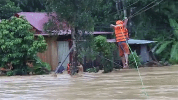 Đi trên dây cứu người bị cô lập giữa dòng lũ