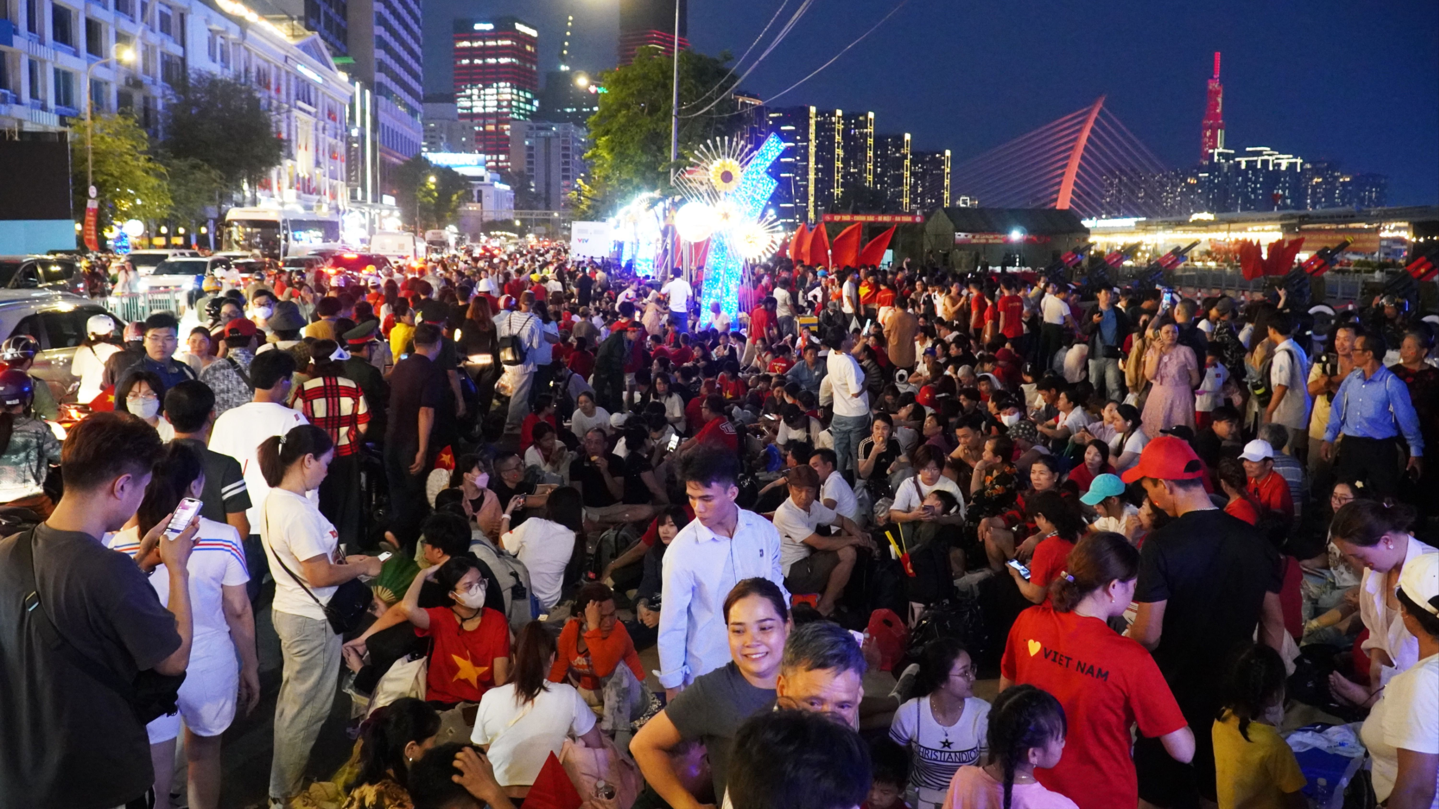 Dòng người tấp nập đổ về trung tâm TP.HCM 'xuyên đêm', đón chờ xem lễ diễu binh, diễu hành sáng 30-4