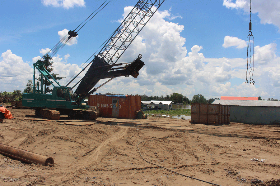 Nhiều máy móc, thiết bị được tập kết tại vị trí bờ sông Tiền chờ mặt bằng để thi công dự án. Ảnh: Đ.HÀ