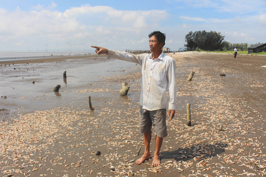 Ông Mai Văn Tia một trong những hộ dân bị ảnh hưởng của sạt lở đứng thẫn thờ bên bờ biển. Ảnh: Đ.HÀ