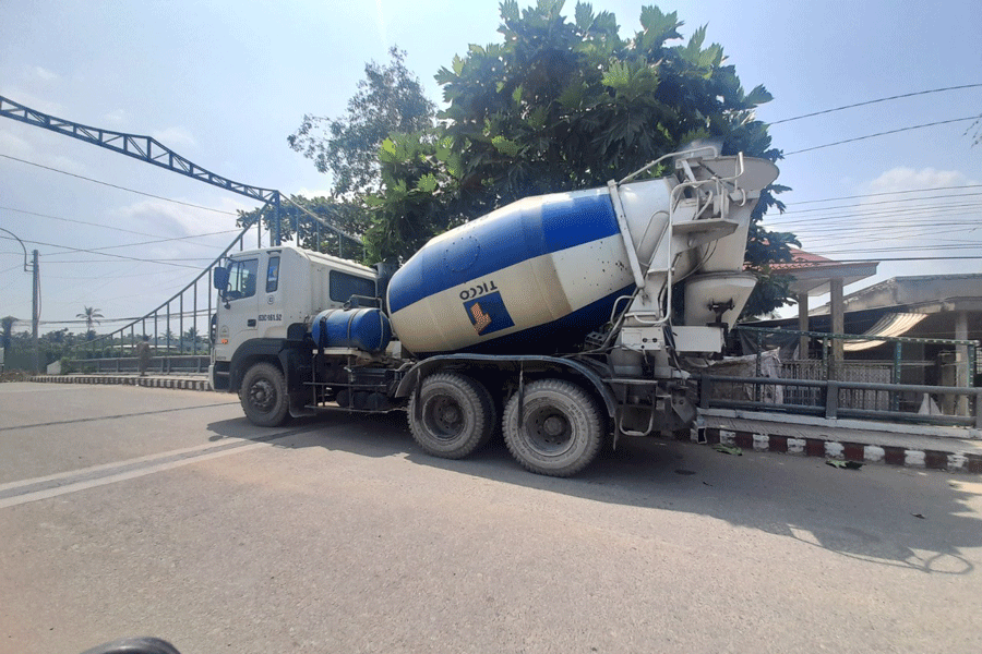 Xe bồn chở bê tông có tải trọng nặng còn ngang nhiên đậu xe trên cầu Cả Sức để chờ vào công trình đổ bê tông thi công lộ nông thôn ở Thới Sơn. Ảnh: PV