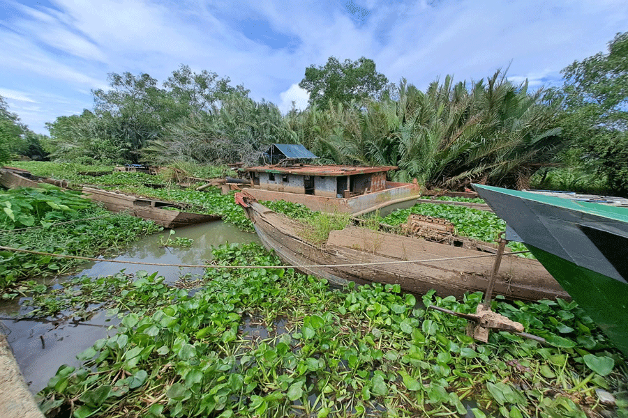 Ghe tàu bị chìm kín mặt sông, gây cản trở dòng nước trên kênh Rạch Đinh. Ảnh: ĐÔNG HÀ