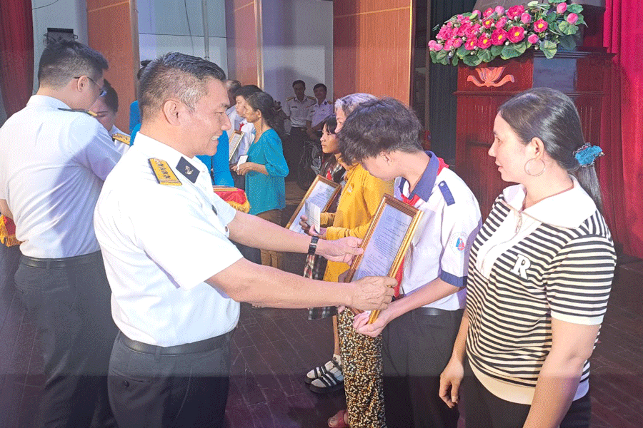 Đại tá Bùi Văn Quỳ trao quyết định nhận đỡ đầu cho 5 người con của ngư dân trên địa bàn tỉnh Bến Tre. Ảnh: ĐÔNG HÀ