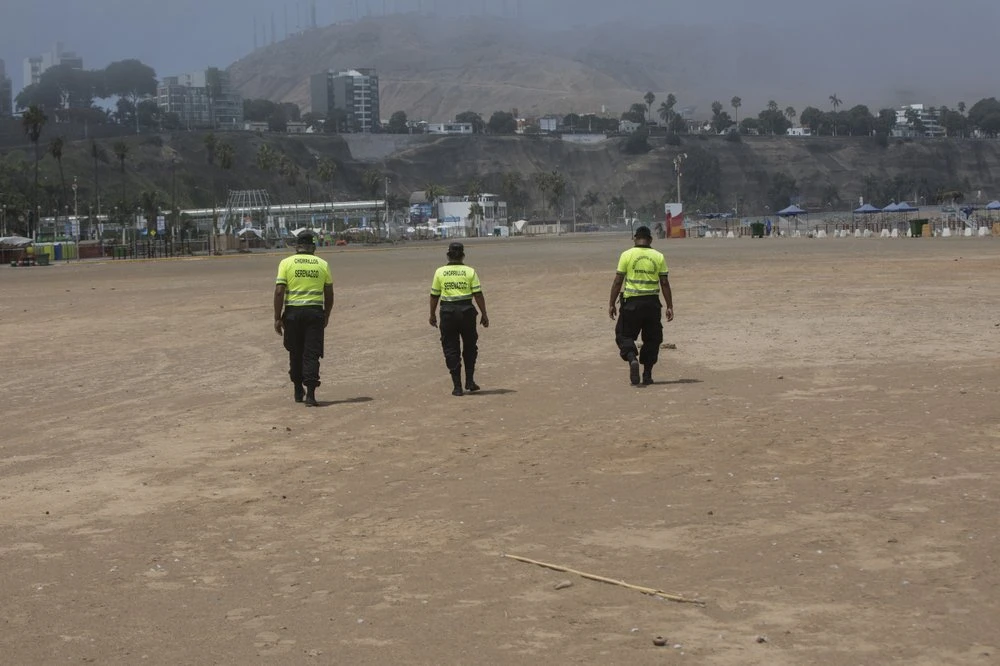 Những nhân viên an ninh ngày 24-3 chỉ còn đi tuần tra trên một bãi biển không một bóng người. Ảnh: AP 2