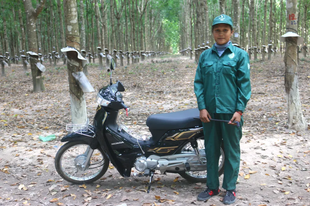 Chị Seng Meakara bên chiếc xe là phần thưởng giải thưởng cao nhất mà chị đạt được trong cuộc thi “Bàn tay vàng thu hoạch mủ cao su”. cao-su-Viet-cong-nhan.JPG