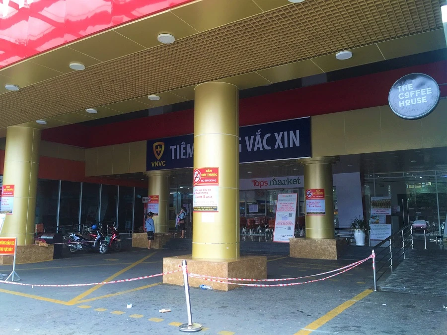 Ảnh trên người dân chờ mua sắm siêu thị Tops Market quận Tân Phú và ngày 23-8 siêu thị thông báo chỉ phục vụ cho khách hàng có phiếu mua hàng được cấp bởi phường Tân Thành và lưu ý khách đi đúng ngày 2