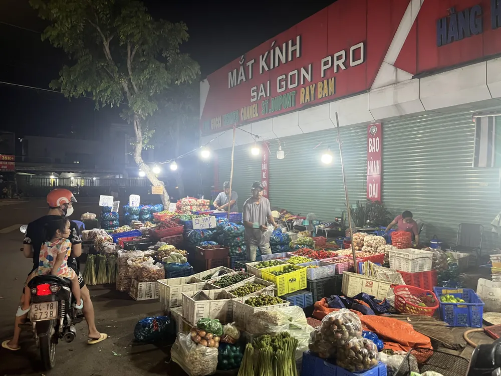 Người dân dừng mua thực phẩm tại điểm bán bên ngoài chợ đầu mối Hóc Môn: Ảnh: TÚ UYÊN chợ đầu mối