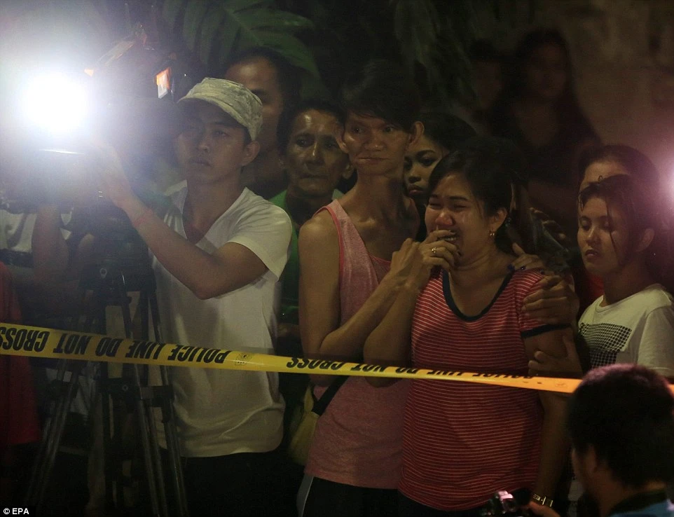 Một phụ nữ người Philippines bật khóc khi thấy xác của chồng mình bên cạnh một tấm biển có ghi 'Tôi là kẻ bán ma túy.