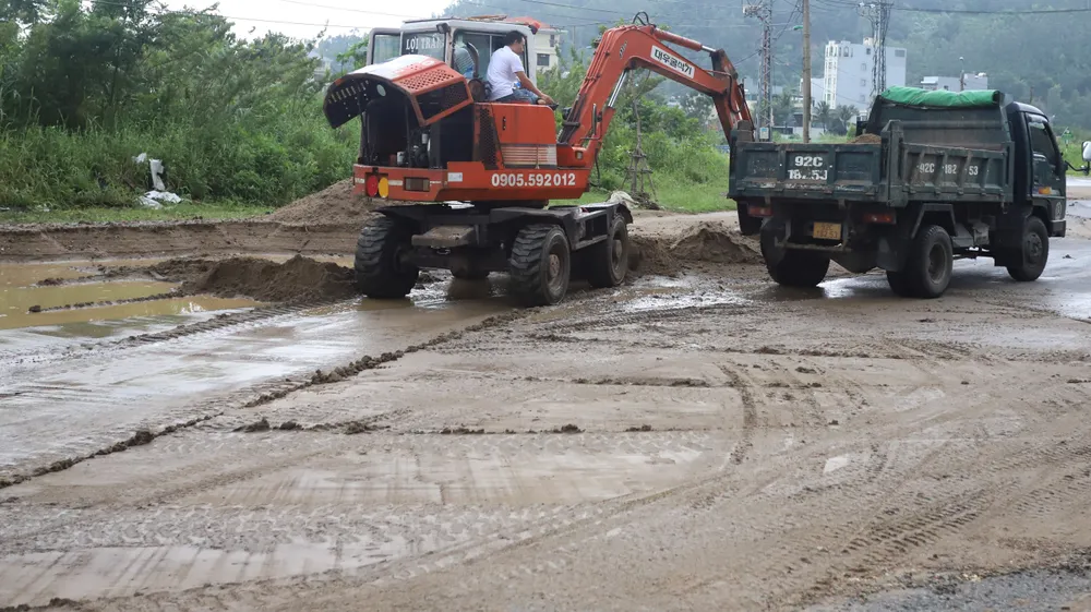 Dọn dẹp đất đá tràn lấp mặt đường Lê Văn Lương, dưới chân bán đảo Sơn Trà. Ảnh: TẤN VIỆT đà nẵng phong tỏa sơn trà chùa linh ứng
