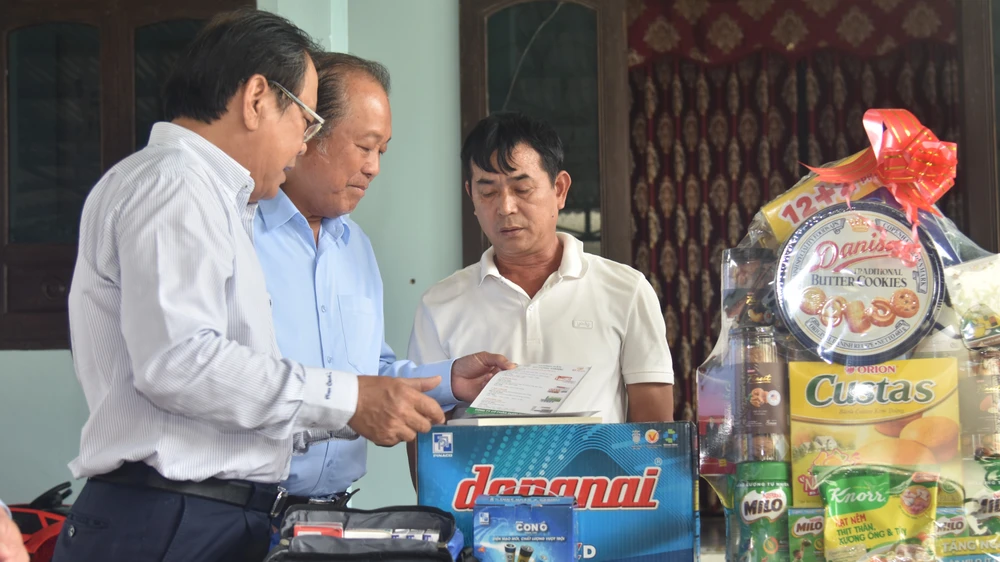Ông Trương Hòa Bình và ông Mai Ngọc Phước trao quà cho ngư dân Phạm Hải. Ảnh: NGUYỄN DO ngư dân đèn trên biển quảng bình