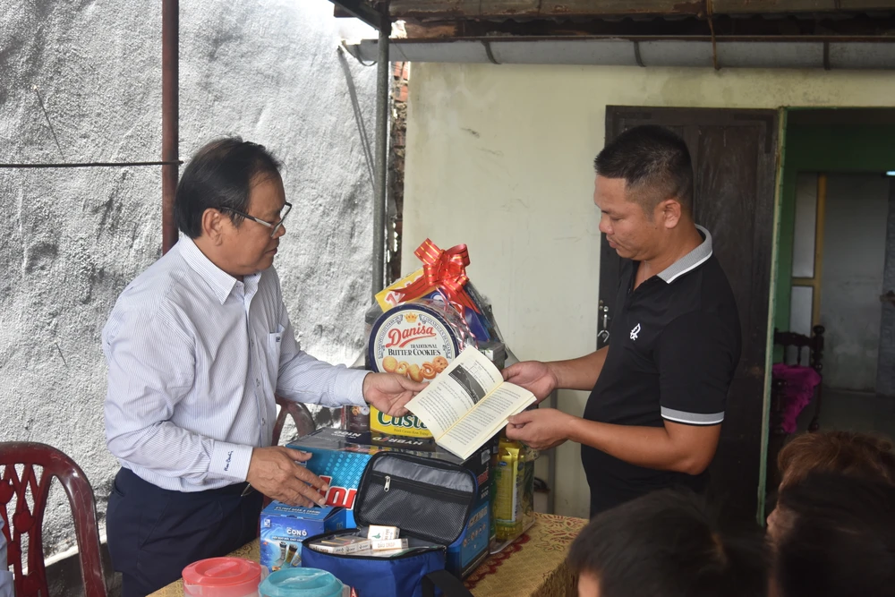 Tổng Biên tập báo Pháp Luật TP.HCM Mai Ngọc Phước trao cuốn cẩm nang "Những điều cần biết về đánh bắt thủy sản" (do báo làm chủ biên) cho ngư dân Nguyễn Thành Biên. Ảnh: TẤN VIỆT ngư dân đèn trên biển quảng bình