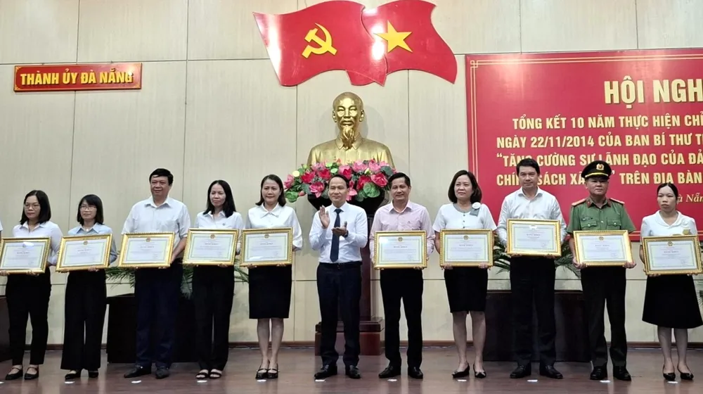 Phó Bí thư Thường trực Thành ủy Đà Nẵng Nguyễn Đình Vĩnh trao bằng khen cho các tập thể, cá nhân xuất sắc trong thực hiện Chỉ thị 40-2014. Ảnh: PV tin-dung-chinh-sach-xa-hoi-da-nang-2.jpg