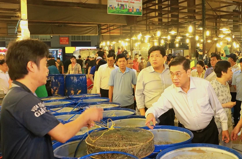 Phó Chủ tịch UBND TP.HCM Nguyễn Văn Dũng trao đổi với tiểu thương tại chợ Bình Điền, quận 8. Ảnh: VÕ THƠ ngộ độc.png