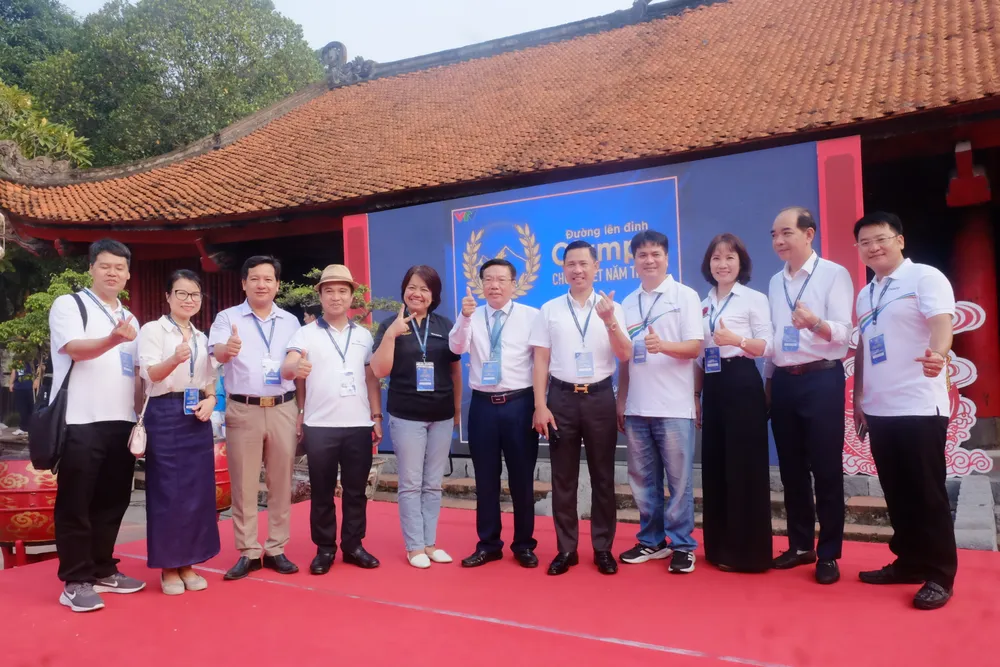 Thầy Vũ Văn Tiến (thứ 6 từ trái sáng) chụp ảnh cùng các thầy cô và Ban tổ chức chương trình Olympia tại điểm cầu Hà Nội. chung kết Olympia 2024