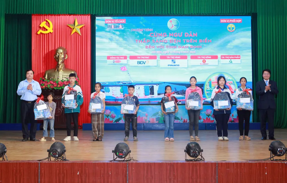 Ông Đinh Đức Thọ, Phó Tổng Biên tập báo Pháp Luật TP.HCM và ông Trần Đức Việt, Phó Giám đốc Sở Nông nghiệp và Môi trường tỉnh Nam Định trao quà cho học sinh. Ảnh: ĐẶNG TRUNG z6511232584633_d2651c726409c84a4b4501e4a557767a.jpg