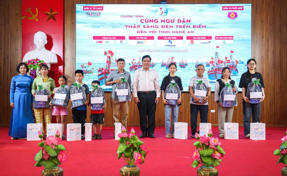 Ông Nguyễn Thái Bình, Phó Tổng Biên tập báo Pháp Luật TP.HCM - Trưởng Ban tổ chức chương trình, cùng bà Đỗ Thị Bích Hạnh, đại diện khu vực Miền Trung của Quỹ Phúc lợi xã hội do Công ty TNHH InfinitiCondo và Chi nhánh Tổng công ty iCD tại Việt Nam quản lý, trao quà cho học sinh. cùng ngư dân 00.jpg