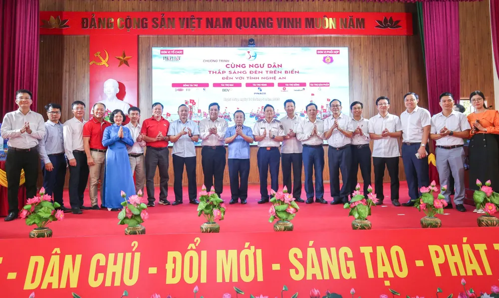 Lãnh đạo UBND tỉnh Nghệ An, báo Pháp Luật TP.HCM cùng lãnh đạo các sở, ngành địa phương và các nhà tài trợ chương trình chụp ảnh lưu niệm. cùng ngư dân 4.jpg