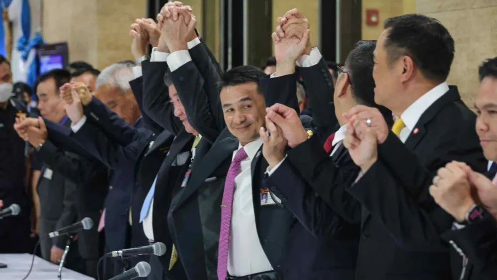 Lãnh đạo đảng Vì nước Thái Cholnan Srikaew (giữa) nắm tay cùng các lãnh đạo trong liên minh tại cuộc họp báo hôm 21-8. Ảnh: Ken Kobayashi/NIKKEI ASIA